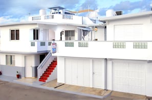 Two-story residential building with a prominent staircase and balcony.