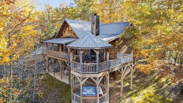 A log cabin with a wooden deck and a hot tub. - Mountaintop Getaway with Gazeebo Deck Hot Tub & Fireplace! Long range views! (Bryson City)