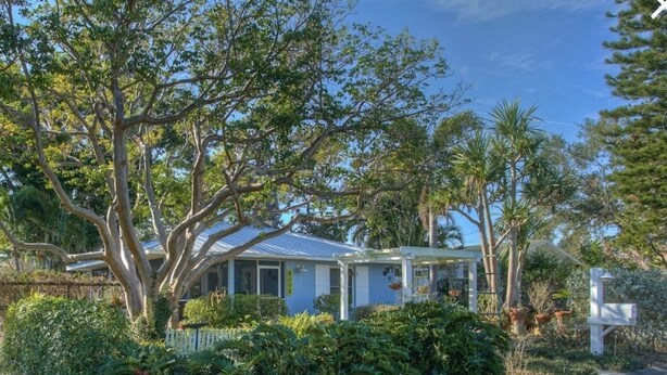A house with a metal roof, surrounded by lush greenery and trees. - Quiet cozy home near Anna Maria Island, Robinson Preserve, DeSoto Nt’l Monument (Bradenton)