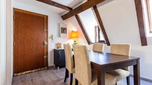 Un comedor con una mesa y sillas de madera, una lámpara y una puerta con detalles decorativos.