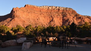 Eine Terrasse mit Sitzgelegenheiten und Blick auf eine rote Felsformation.