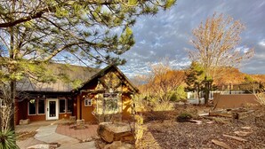 Ein rustikales Holzhaus mit Steinfassade, einer Holzveranda und einem Steinweg, der zum Eingang führt.