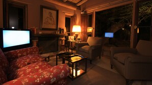 Una sala de estar acogedora con chimenea, asientos cómodos y televisor.