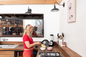 Refrigerador em uma área comum, talheres/pratos/utensílios de cozinha