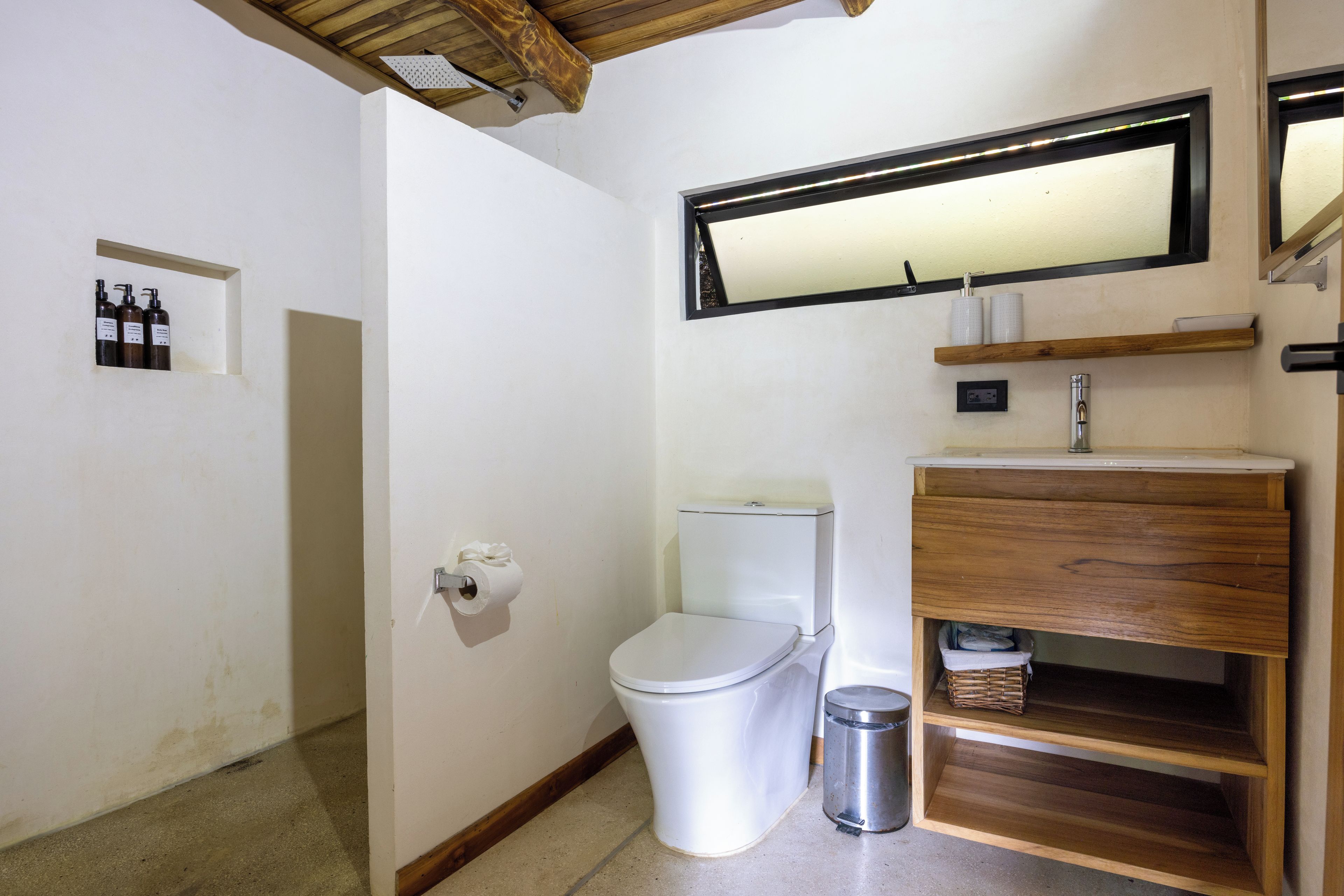 Un baño pequeño y funcional con inodoro, lavamanos y espejo.