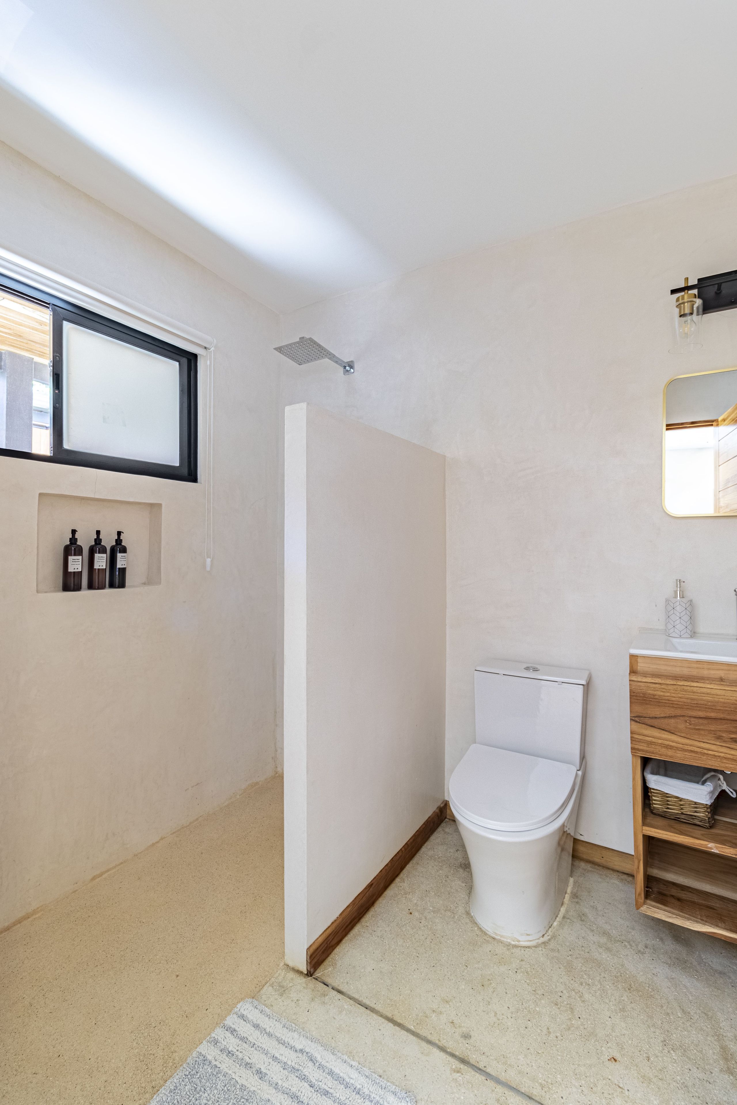 Un baño pequeño con ducha, inodoro y una zona de tocador.