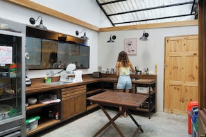 A compact kitchen with wooden cabinets, a sink, and a countertop. - Believe Surf & Yoga Lodge Santa Teresa - Hostel (Cóbano)