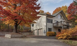 Une maison à deux étages avec un balcon, un garage et une allée.