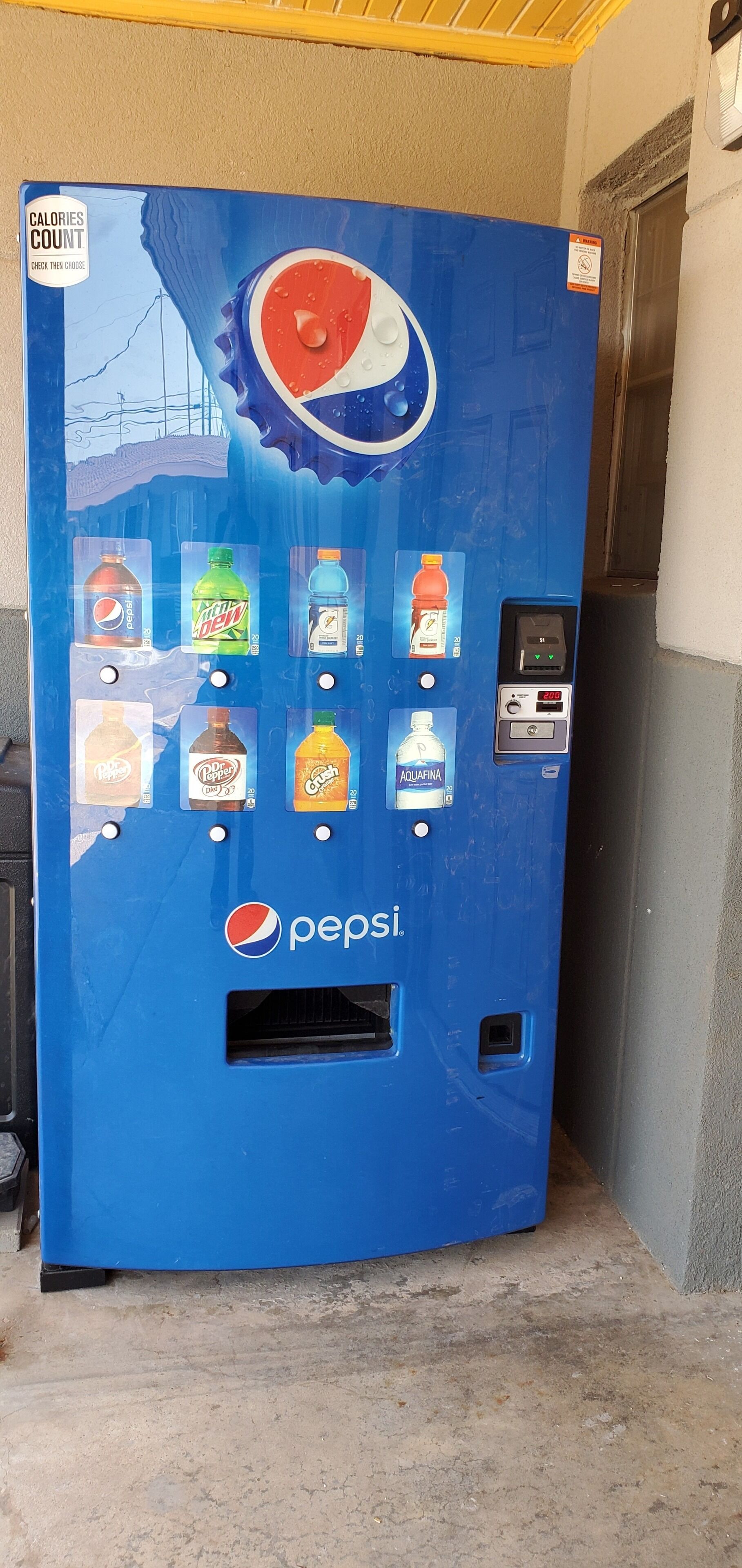 A blue vending machine with the Pepsi logo, offering various beverages including Pepsi, Mountain Dew, and Aquafina water.