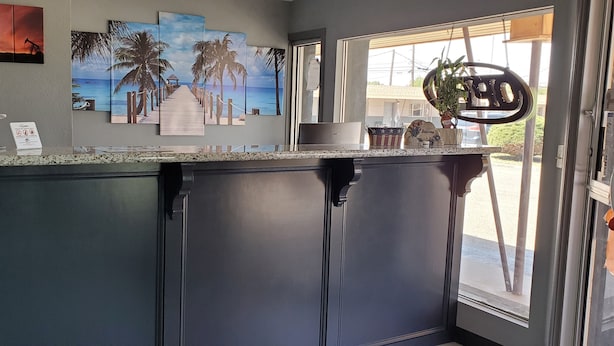 A kitchen with a granite countertop, a coffee machine, and a view of the outside. - Crescent Park Motel & Suites (Littlefield)