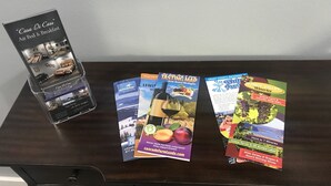 Un expositor con un folleto de 'Casa Di Cass', un folleto de 'Mapa de Degustación' y un folleto de 'Grant County Washington'.