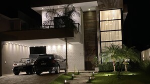 Une maison moderne dotée d’un garage, d’une allée et d’un chemin bien éclairé.