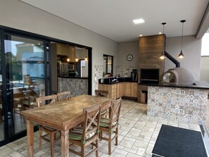 A modern kitchen with a built-in oven, wooden dining table, and chairs.