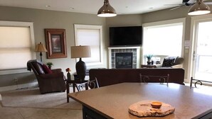 A kitchen with a central island, dark cabinetry, and a stone countertop. - This riverfront downtown condo boasts and open floor plan for kitchen, living room, and dining areas. Or step onto the balcony over the Arkansas River to hear the water rushing by. Oversized master suite has its own balcony and indoor sitting area. (Salida)