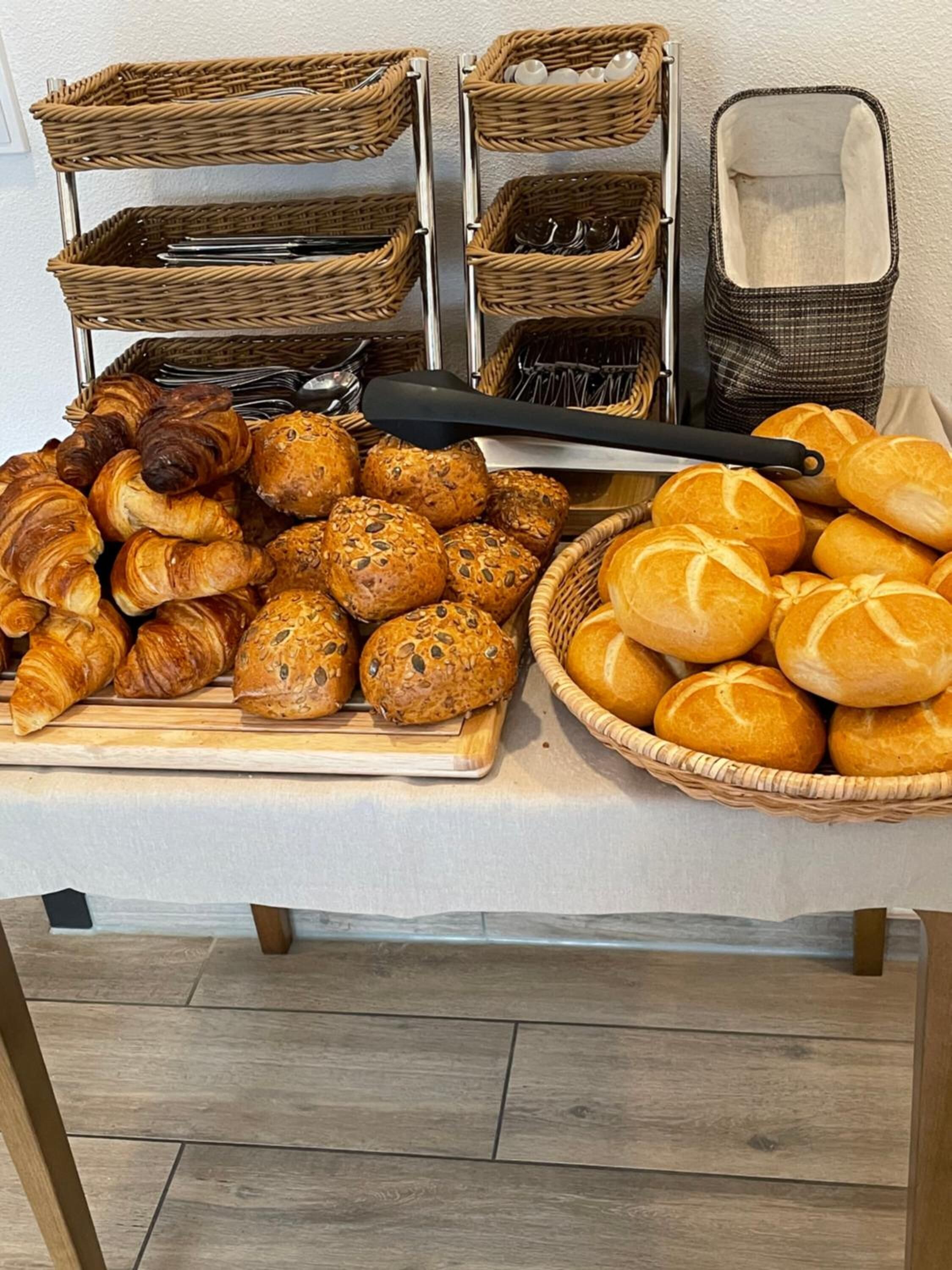 A display of various baked goods including croissants, bread rolls, and baguettes.