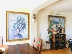Un comedor con una mesa de madera, sillas y un mueble con adornos.