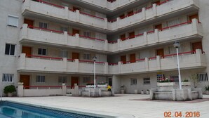 Un edificio de varios pisos con zona de piscina.