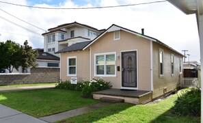 A single-story house with a front porch, a small garden, and a mailbox.