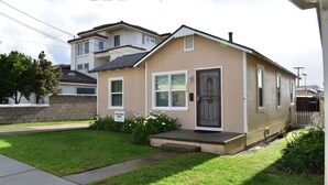 A single-story house with a front porch, a small garden, and a mailbox.