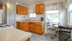 A kitchen with wooden cabinets, a coffee maker, and a window with curtains. - 369 Stimson: 3 BR, 2 BA House in Pismo Beach, Sleeps 8 (Pismo Beach)