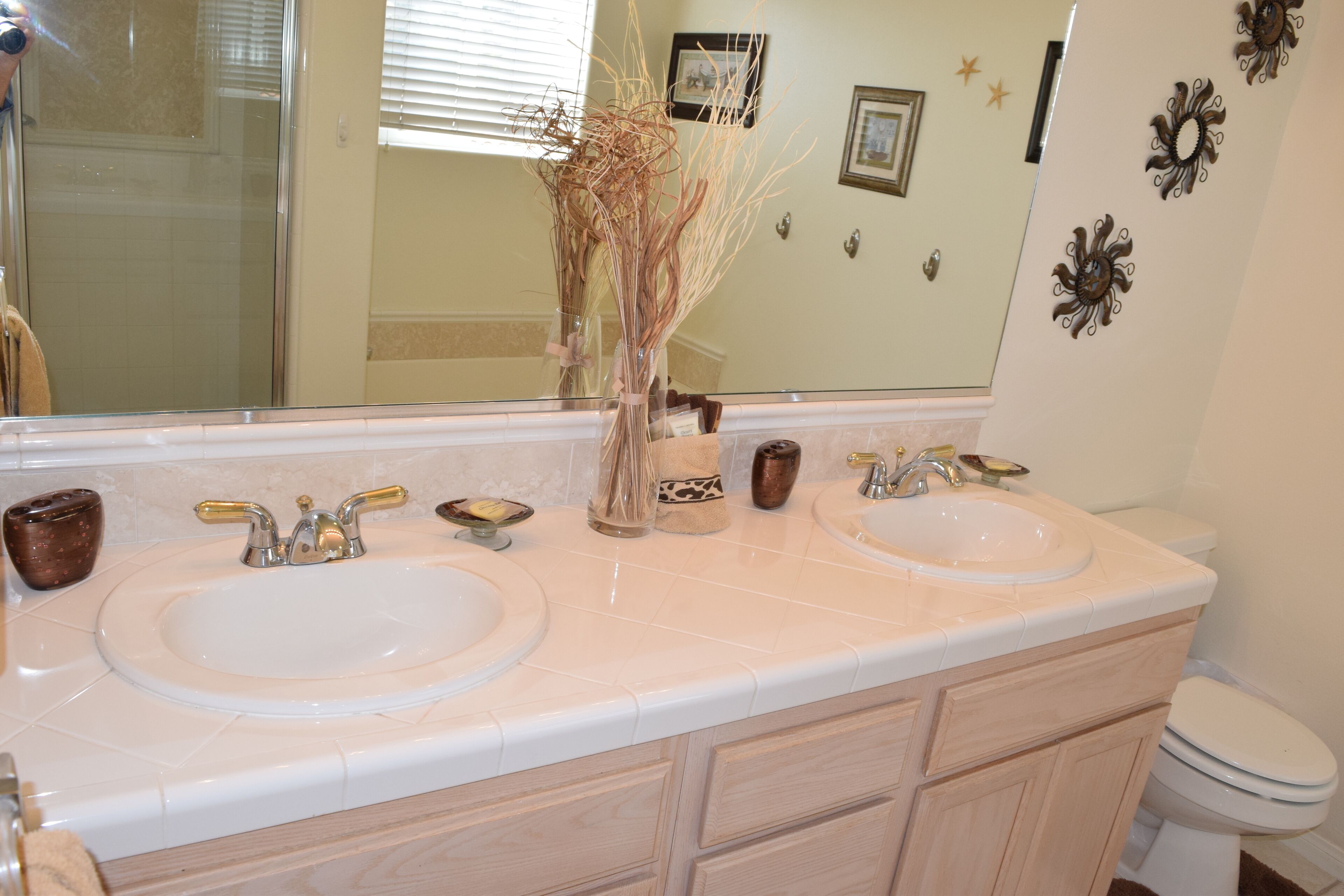 A bathroom with two sinks, a mirror, and a toilet.