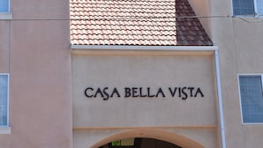 En byggnad med en skylt som visar texten ”CASA BELLA VISTA” ovanför en välvd entré.