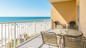 A balcony with a view of the beach and ocean, a round table with chairs, and a white railing. - Seawind 403: Updated, child friendly Beachfront, Best location in Gulf Shores (Gulf Shores)