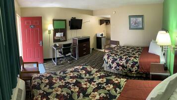 Une chambre d’hôtel avec deux lits, un bureau, une chaise, une télévision et une porte.