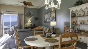 Un coin repas avec une table ronde, des chaises en bois et un lustre.