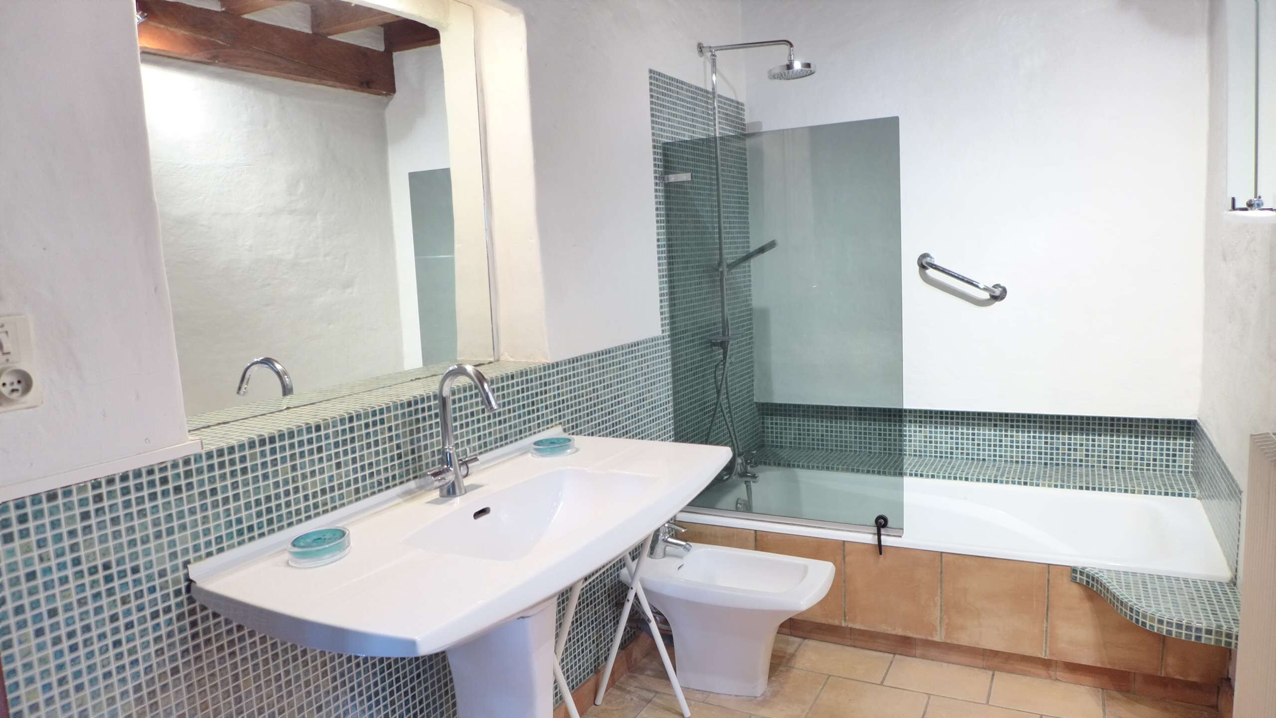 A bathroom with a white sink, a glass shower enclosure, and a bathtub.