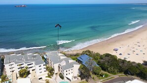 Un hôtel situé sur la côte, composé de plusieurs bâtiments, avec une plage et une vue sur l’océan.
