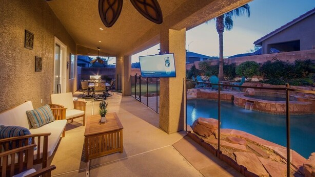 Un espace extérieur aménagé avec une terrasse, une piscine, des sièges et un écran de télévision.