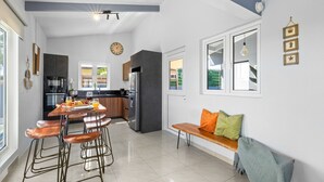 A modern kitchen with a dining area, a bench, and a view of the outdoors.