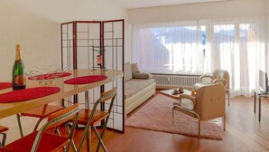 Un salon moderne comprenant un coin repas, un canapé, une table basse et un radiateur.