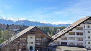 Une station de montagne avec des bâtiments en bois et une vue sur des sommets enneigés.