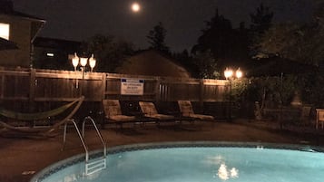 Una piscina al aire libre de temporada, sombrillas