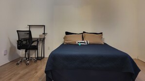 A bedroom with a bed, a desk with a chair, and a ceiling fan. - Alabama Rd S Rancher (Lehigh Acres)