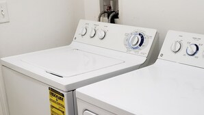 A laundry area with two front-loading washing machines. - Alabama Rd S Rancher (Lehigh Acres)
