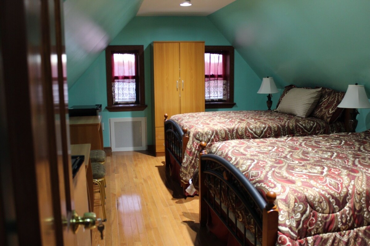 A bedroom with two beds, a wardrobe, and a radiator.