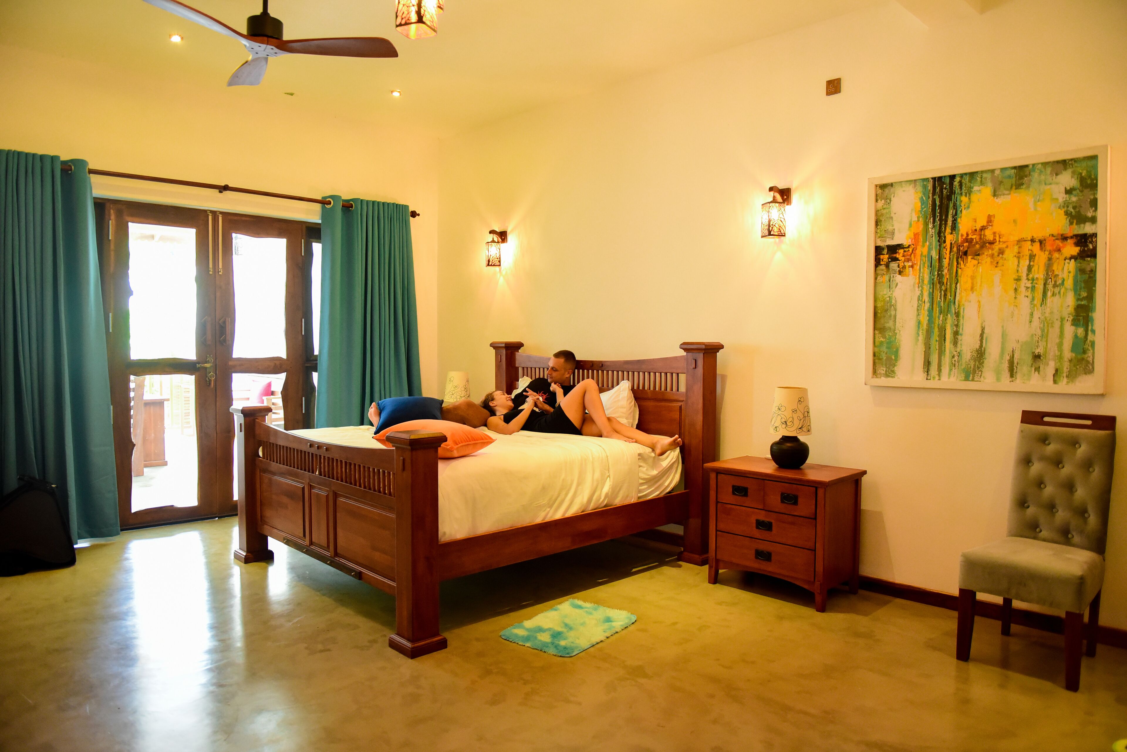 A bedroom with a wooden bed, a nightstand, a chair, and a painting on the wall.