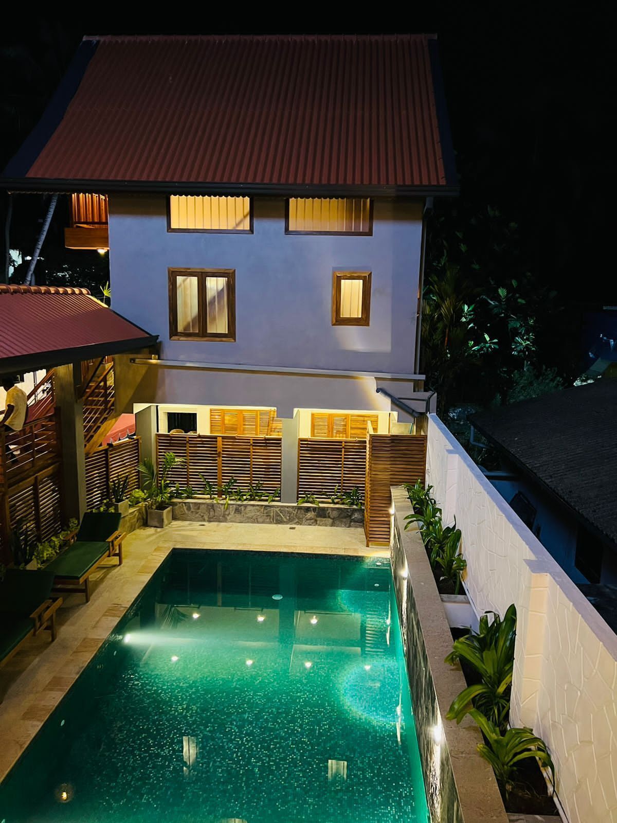 A two-story house with a swimming pool in the backyard.