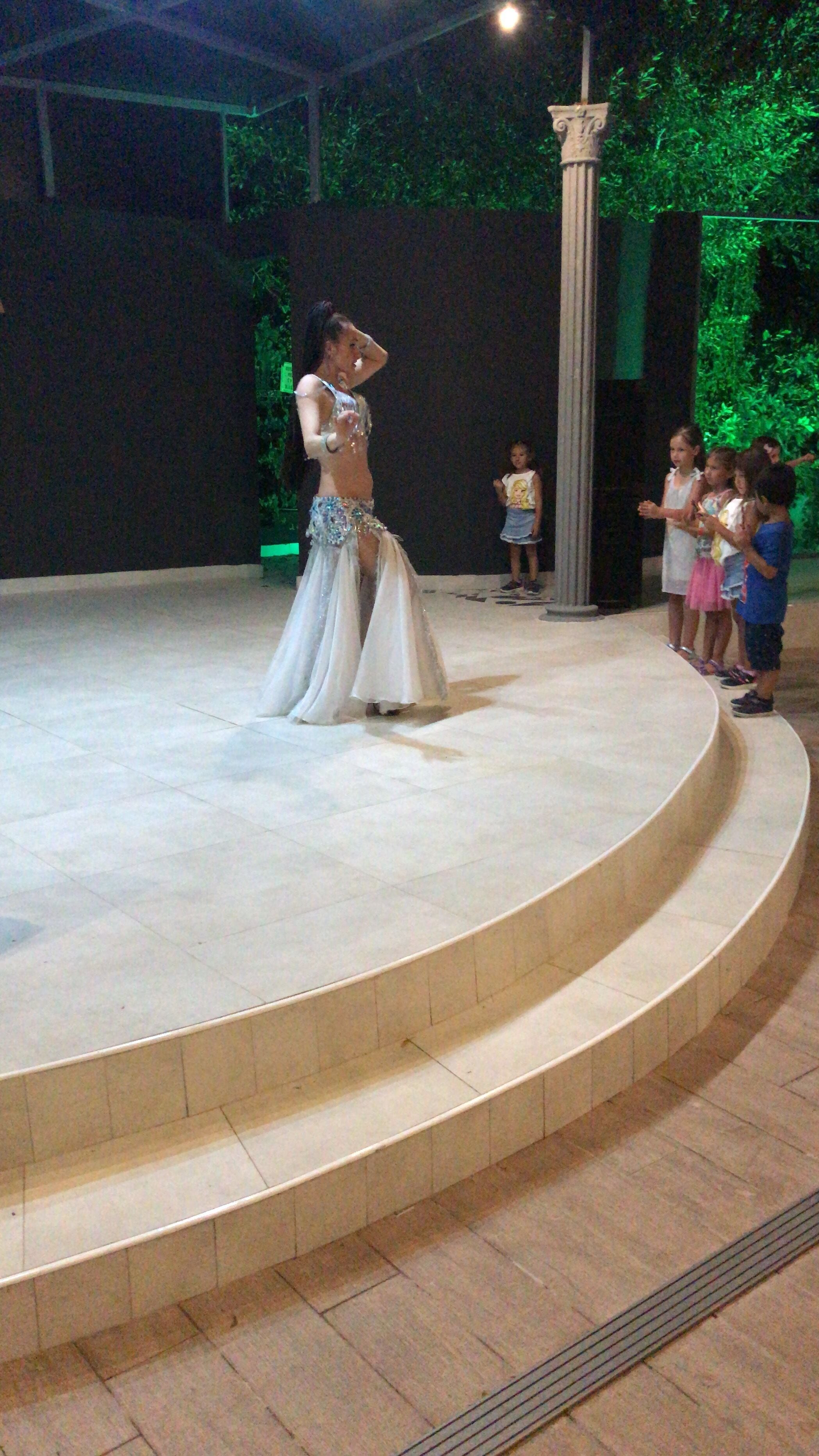 A stage with a performer in a costume, surrounded by an audience.