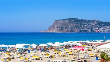 On the beach, sun loungers, beach umbrellas, motor boating