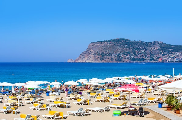 On the beach, sun loungers, beach umbrellas, motor boating