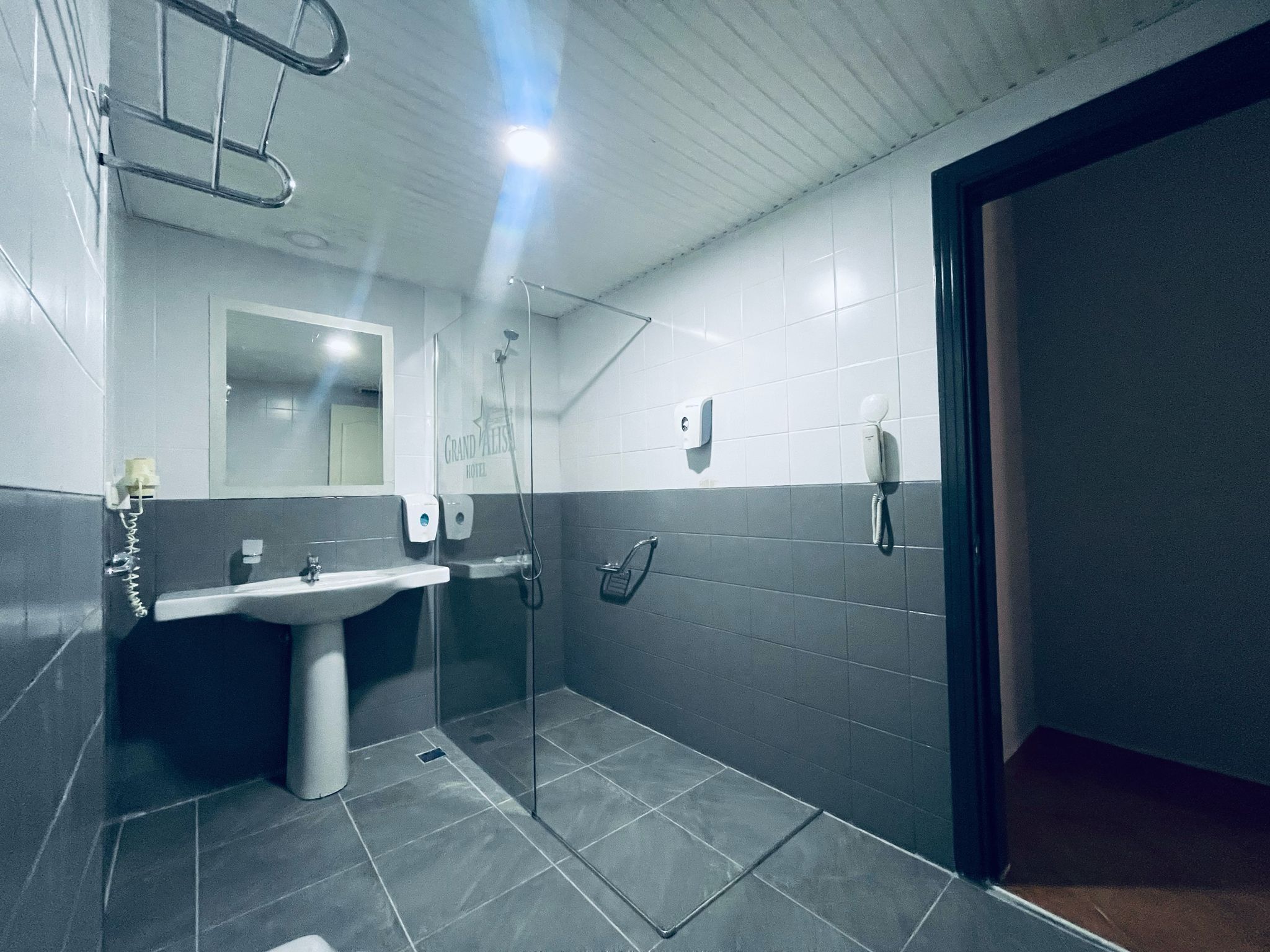 A modern bathroom with a sink, mirror, and shower.