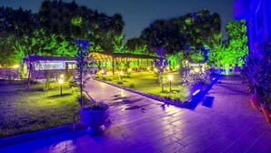 A well-lit outdoor area with a covered seating area, pathways, and potted plants. - Grand Alisa Hotel – Ex.Royalisa Hotel (Alanya)