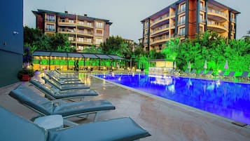 Een buitenzwembad en ligstoelen