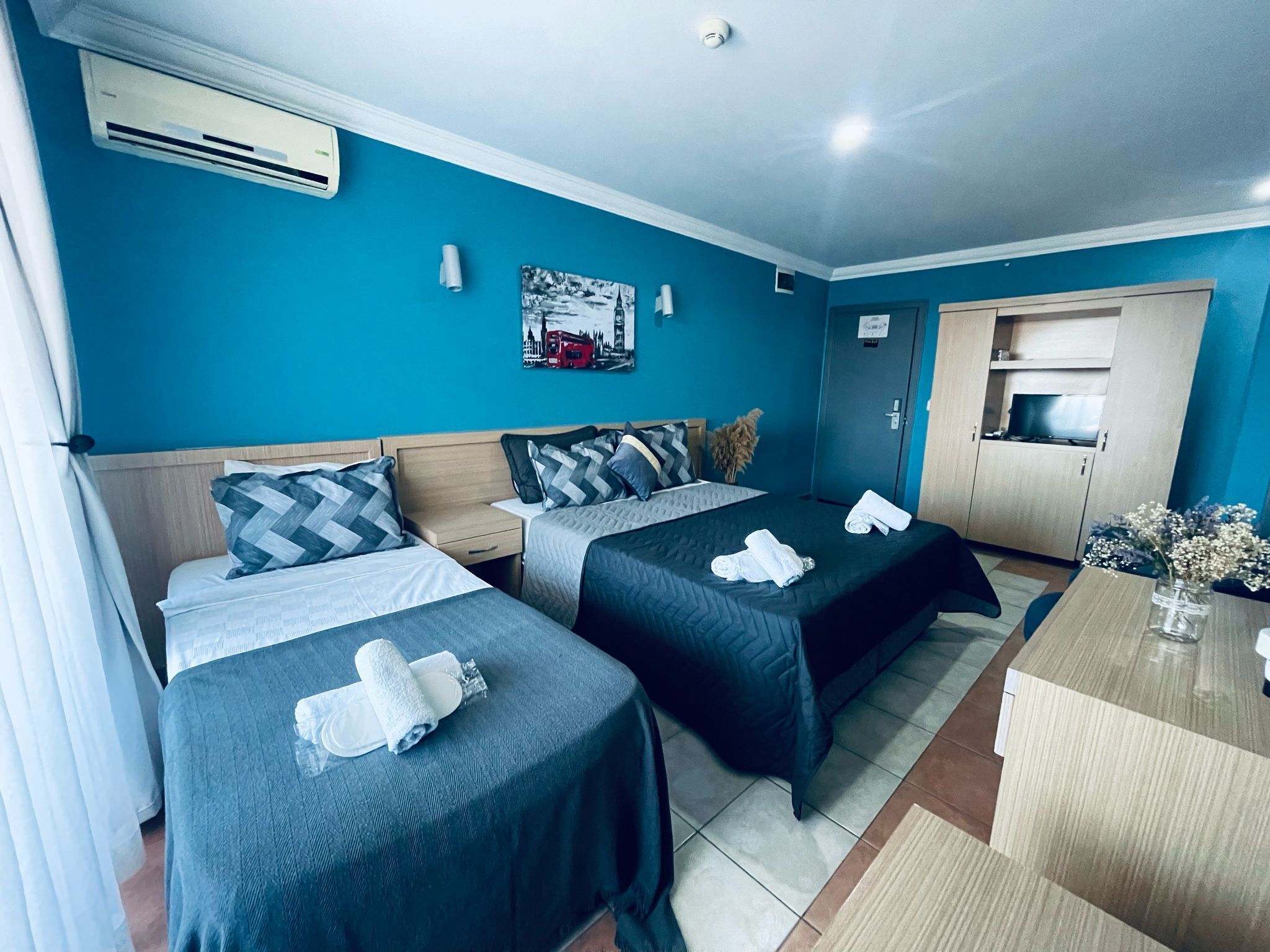 Une chambre d’hôtel avec deux lits, une kitchenette et une salle de bain.