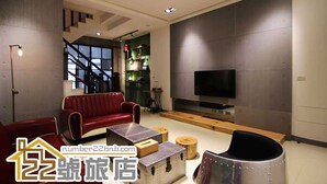 Una sala de estar moderna con un sofá rojo, una mesita de centro y un televisor.
