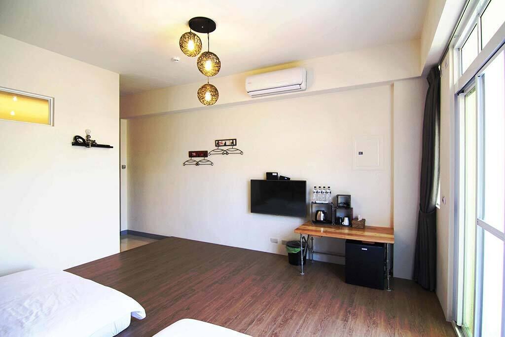 Une chambre d’hôtel équipée d’un lit, d’un bureau avec un ordinateur, d’une télévision et d’un appareil de climatisation.